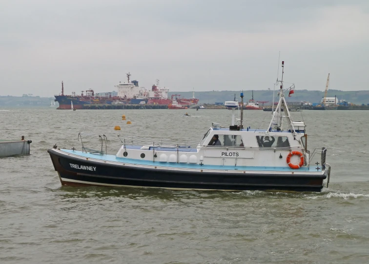 a white and black boat is sailing near several boats