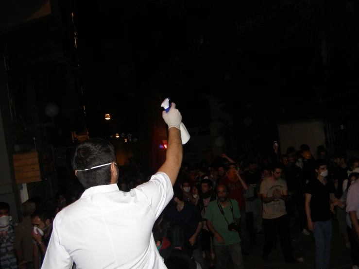 a man holding a wii controller in front of a crowd