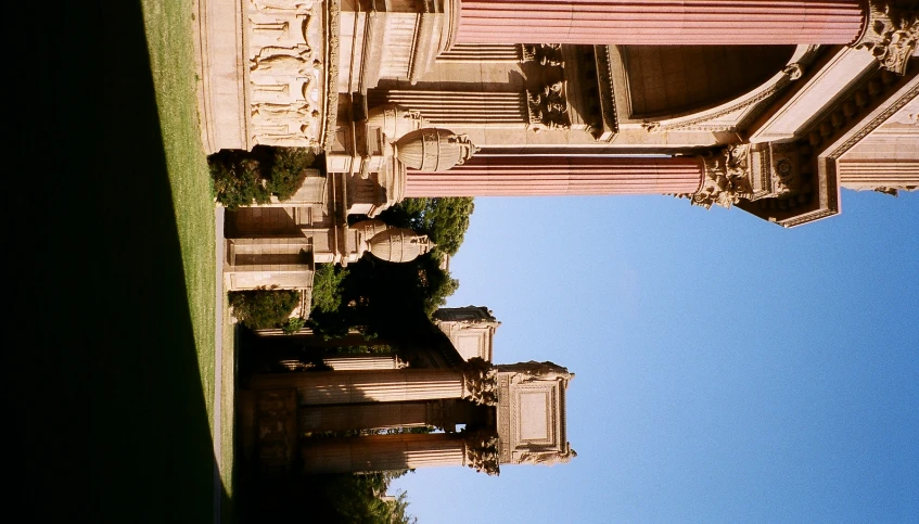 a building that has statues and a bench on the other side