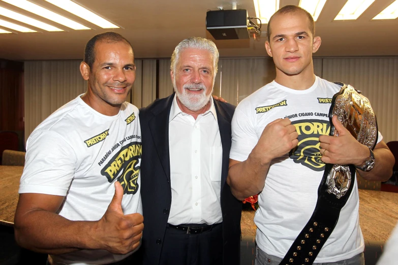 three men pose for a po with their belts