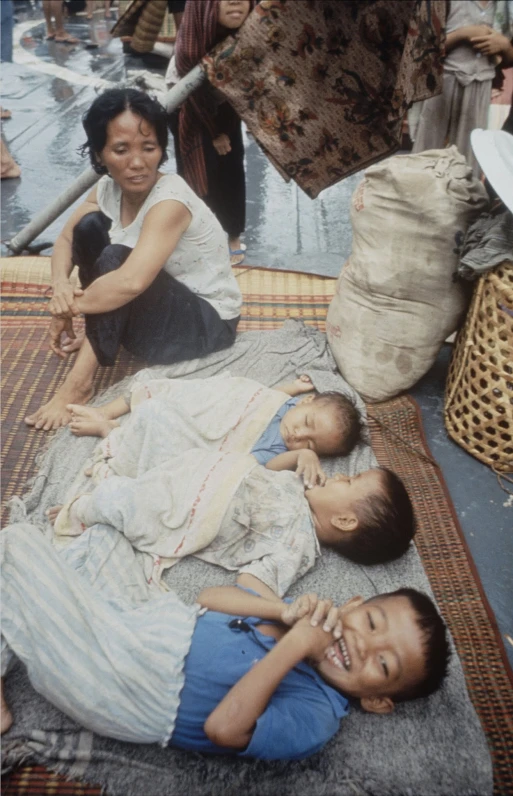 three children are in a carpet together in a crowd