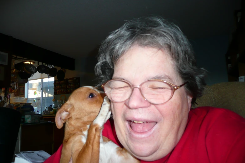 an old woman holding her dog and smiling