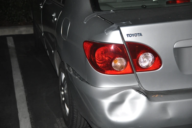 a small car in a parking lot parked next to a street