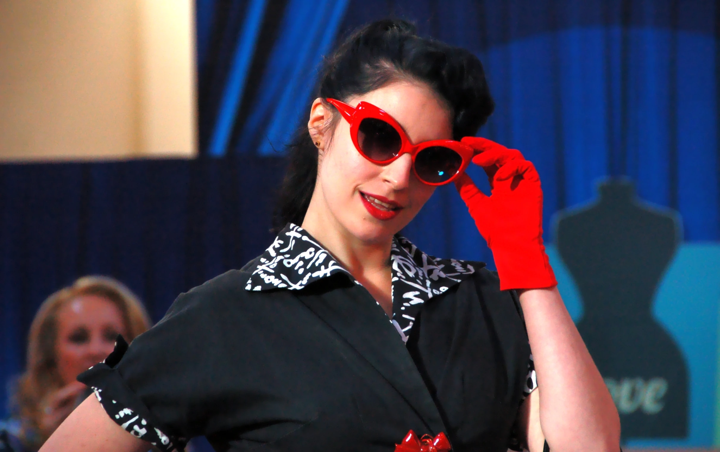 a woman with red gloves and red gloves on, wearing sunglasses