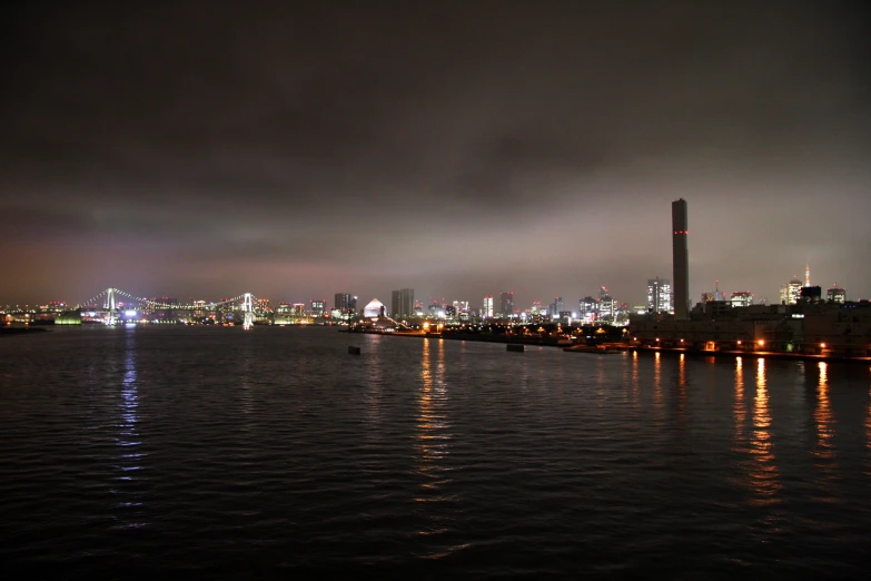 the city lights are reflecting in the water