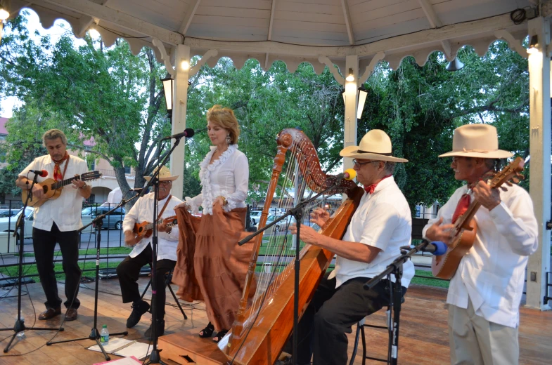 a group of people play music in a gazebo