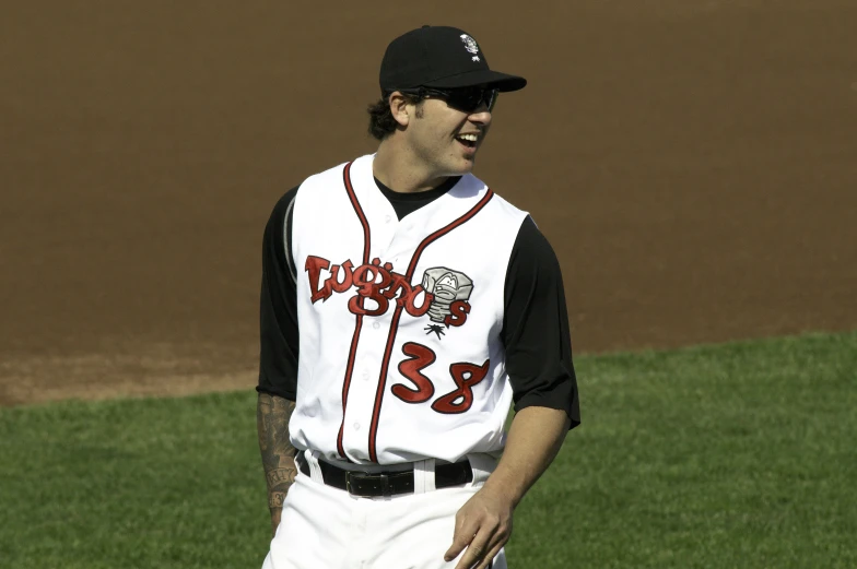 a baseball player laughs while standing on the field