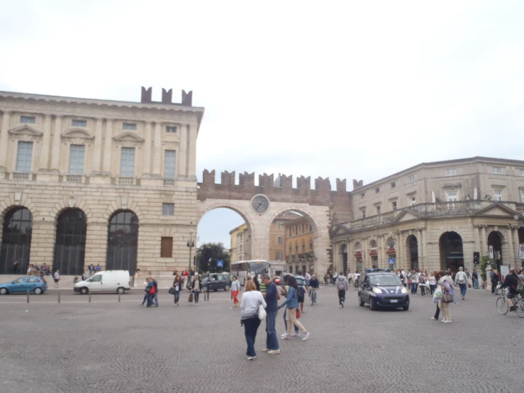 some people are walking around in front of a large building