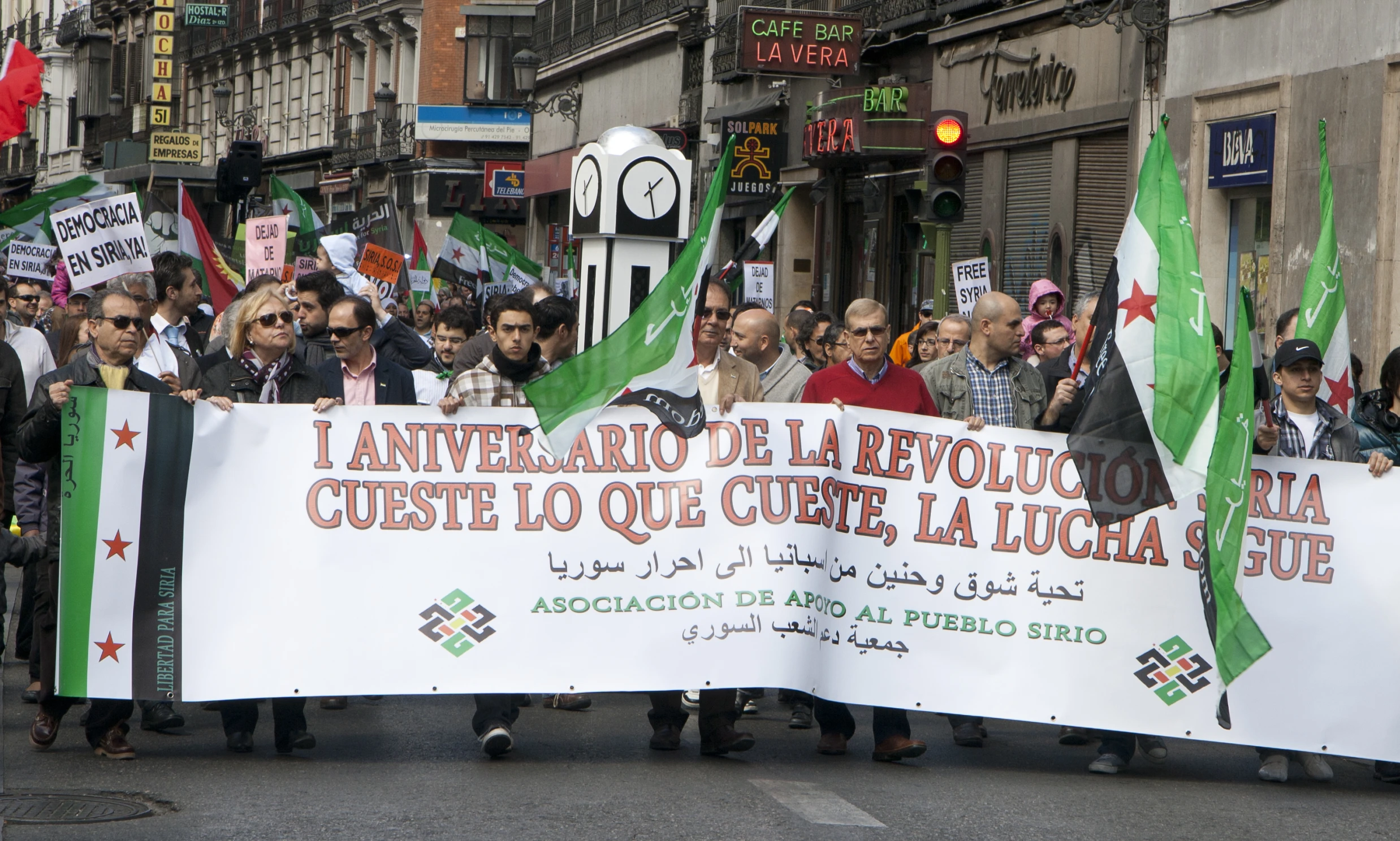 large group of people holding flags and signs with an ornate pattern