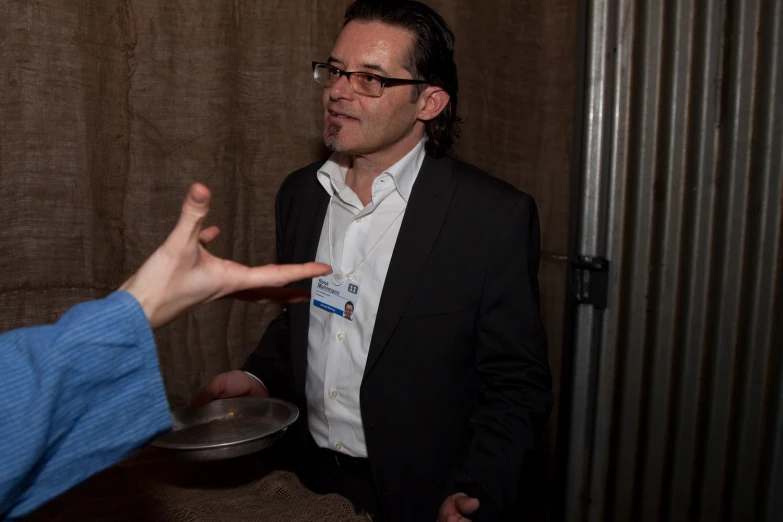 two men in suits having some conversation while one points at soing