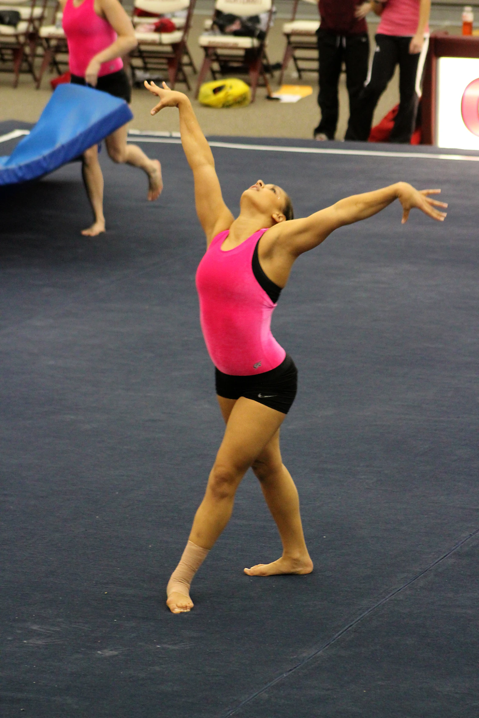 a ballerina is stretching her leg out to serve