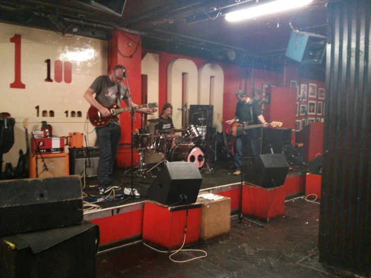 four people playing instruments in front of a screen