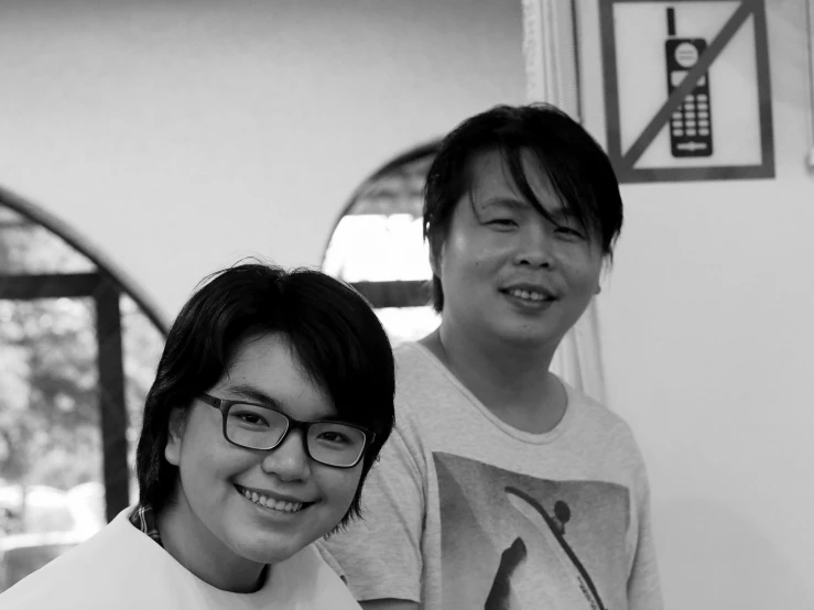 two asian boys stand together smiling at the camera