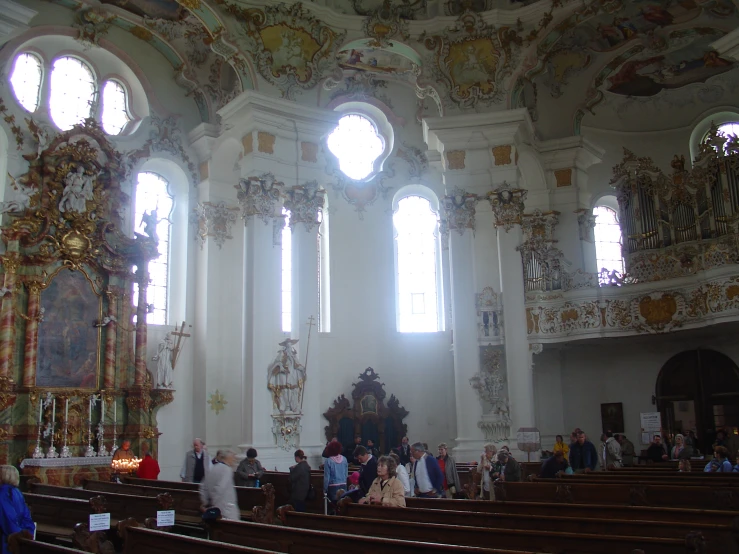 many people in church during the day with lights streaming through the windows