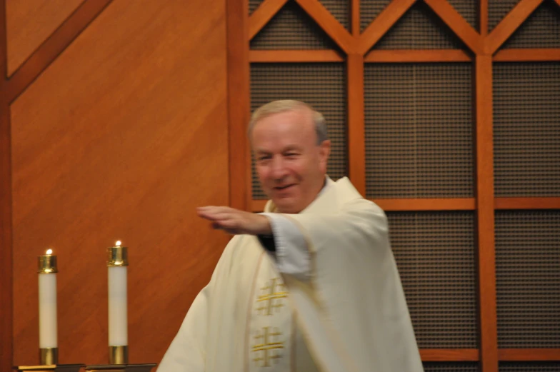 a priest pointing to the altar with candles