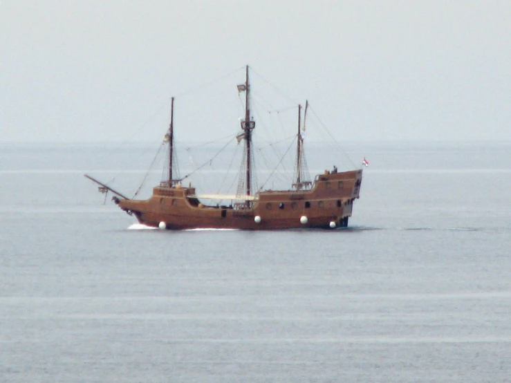 a brown boat out on a body of water
