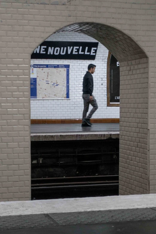 a man is walking down the subway platform