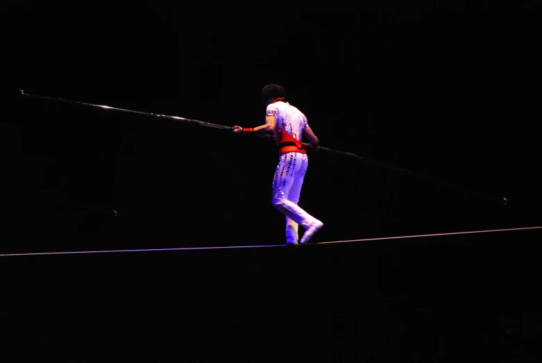 the man is balancing on a tight rope