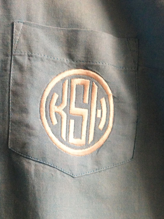 a on down shirt with an embossed initials on it