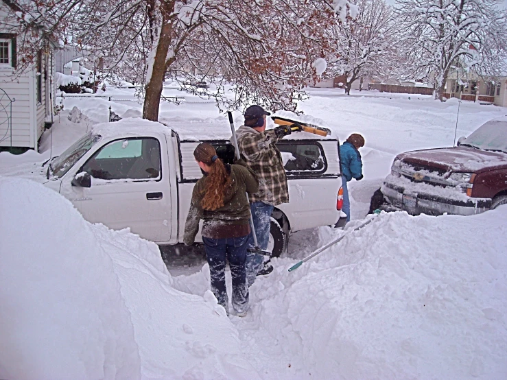 a couple of people stand next to a white truck