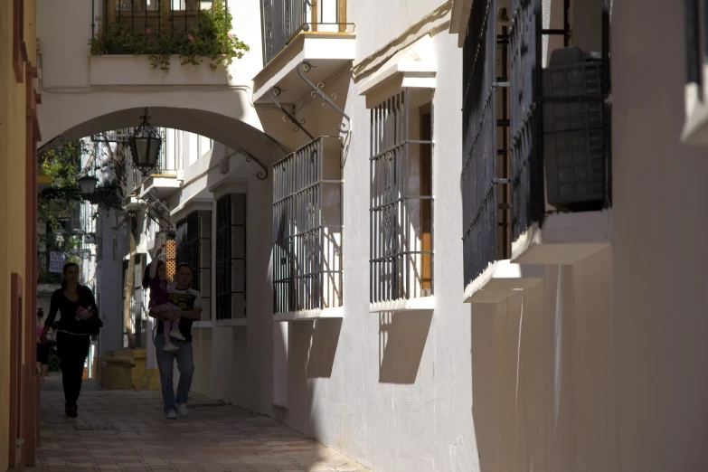 people are walking down an old narrow street