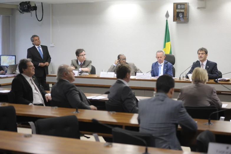 group of people sitting around tables during meeting in room