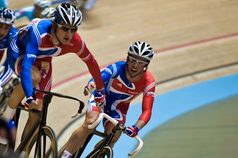 two cyclists in british cycling uniforms racing on a track