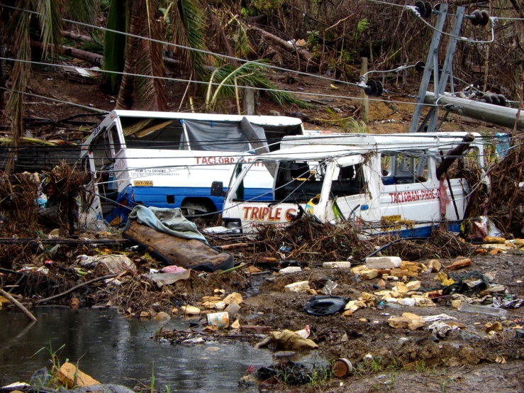 a bus is parked in a junkyard next to a body of water