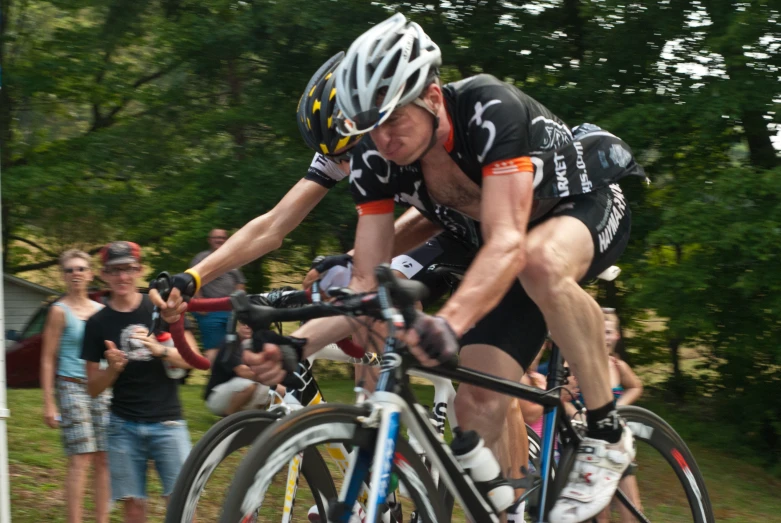 man riding bike at a race in front of a crowd