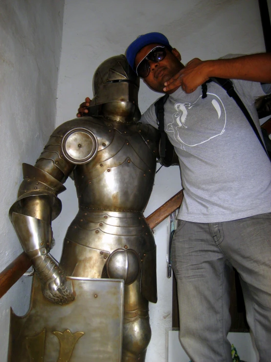 a man standing next to a knight statue