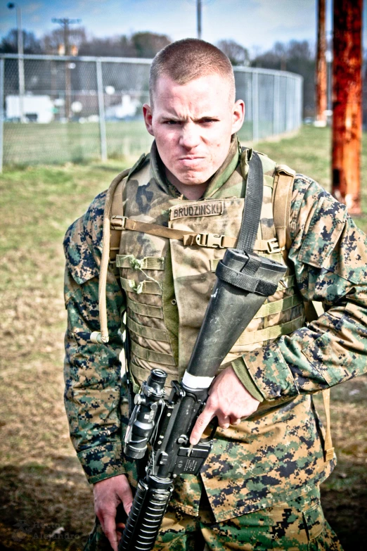 a man in camouflage holding a gun on a field