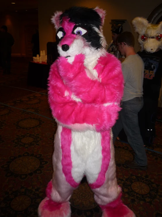 a mascot stands with a pink and white coat