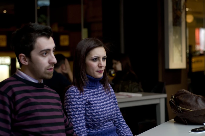 two people are sitting down at a table