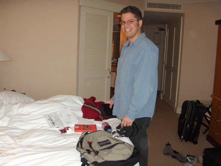 man with luggage and other items in the bedroom