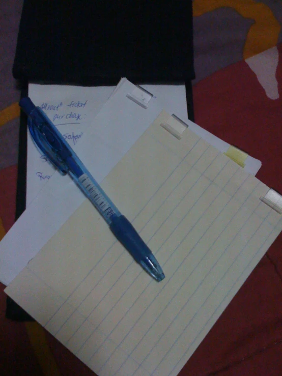 notepad and pen on a desk with a paper attached