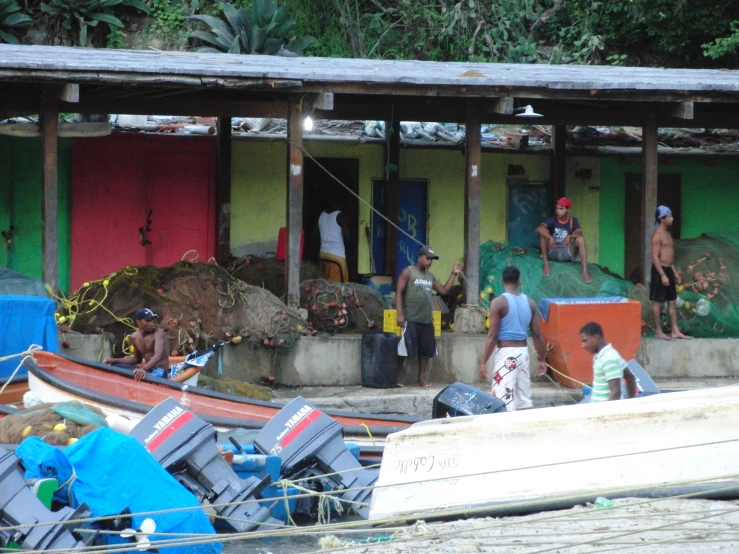 a group of people standing next to boats in a harbor