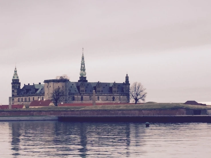 a big castle with a tower on it's top next to the water