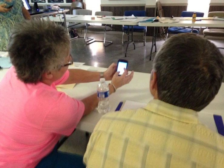 a woman taking a picture of another man with a cell phone