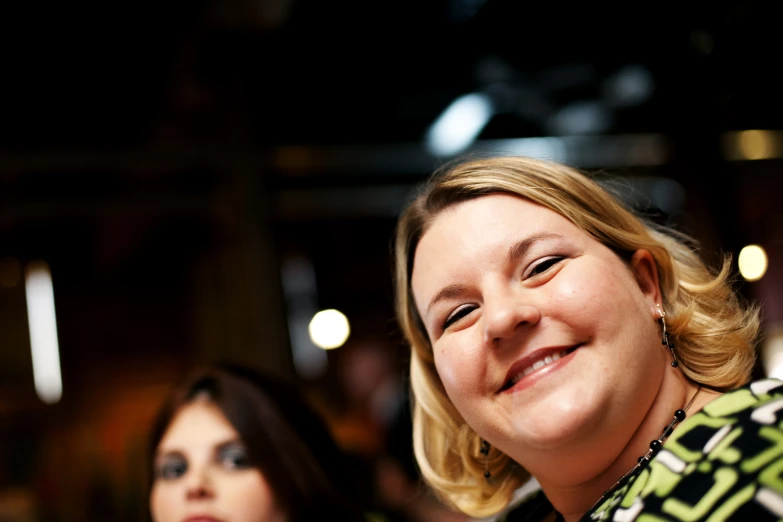 two women smiling at an event together