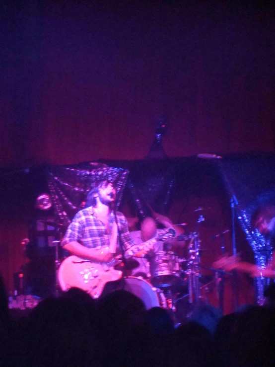 two people playing guitar in front of an audience