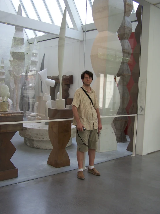 a man stands in front of a variety of vases