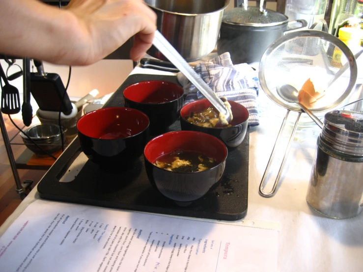 a person spoons in food in small bowls