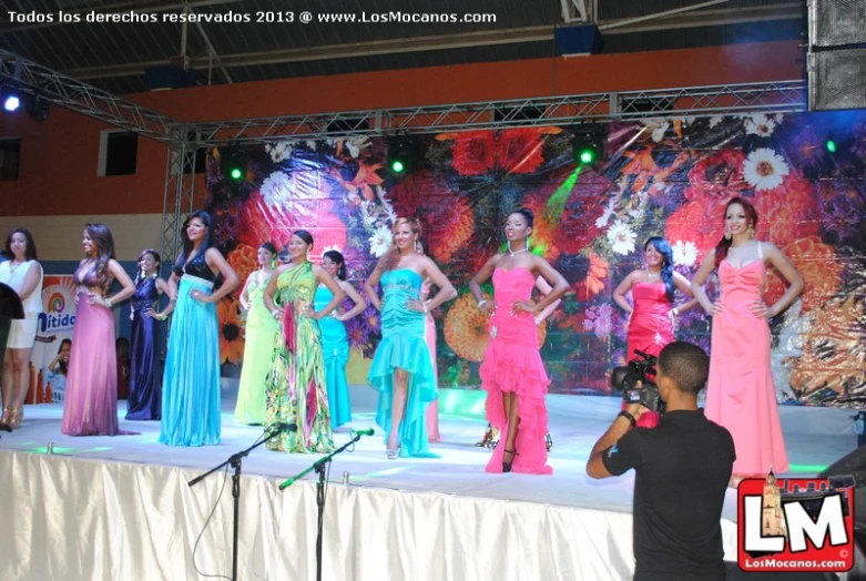 the contestants are on stage, while the man takes pictures