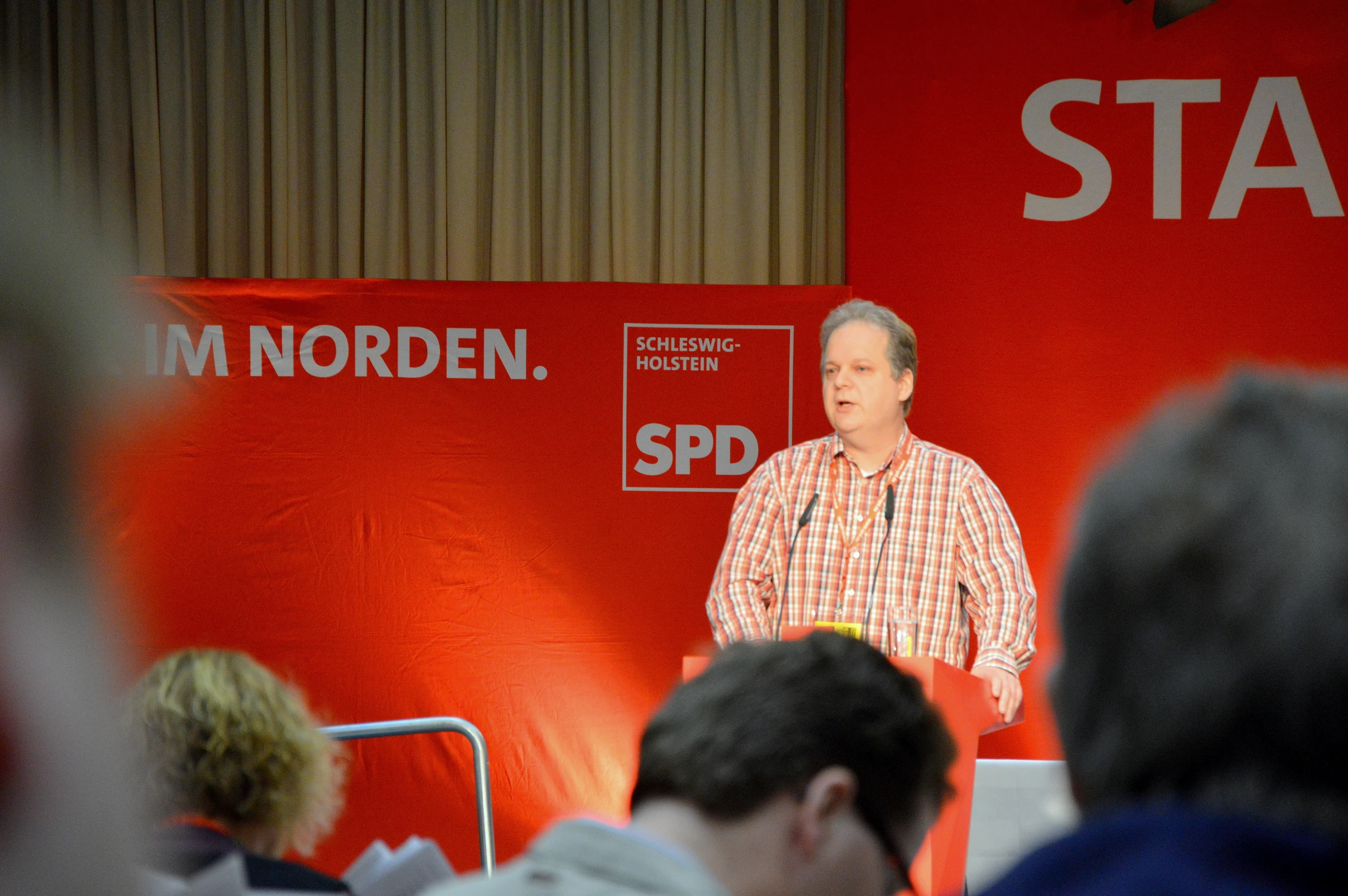 a man giving a speech to a crowd at an event