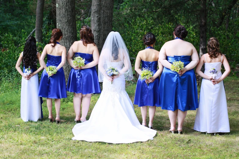 a group of women in dress looking into the woods