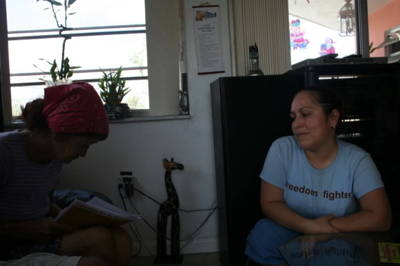 a woman and child reading a book in a room