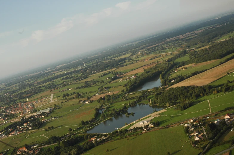 an aerial view of the country side with a lake in the foreground