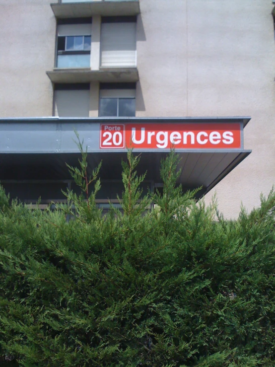 a red 20 hurricanes sign over bushes in front of a building