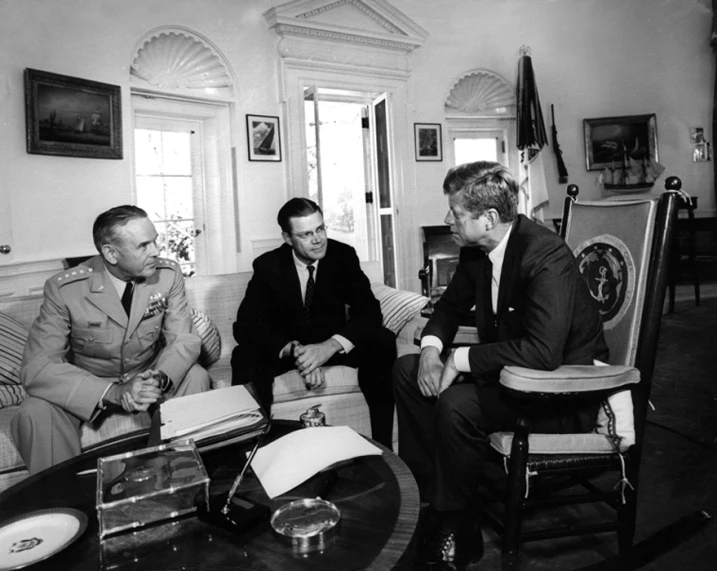 two men sit with two others in a room