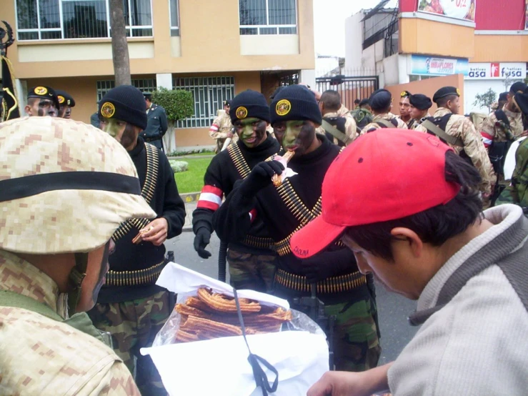 some people wearing black uniforms and hats, with the men behind them